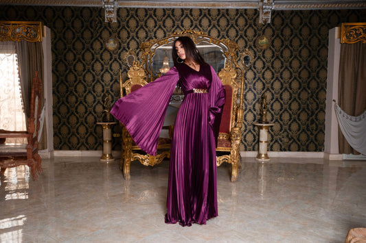 Burgundy pleated jumpsuit with gold chain belt with sleeves